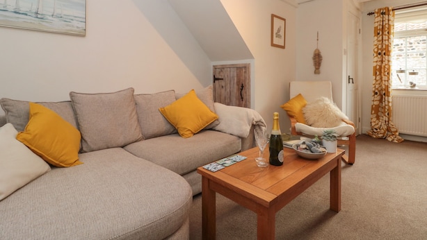 Un salon chaleureux avec un canapé, une table basse en bois et un fauteuil.