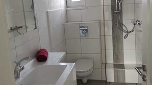 Ein modernes Badezimmer mit Dusche, Toilette und Waschbecken.