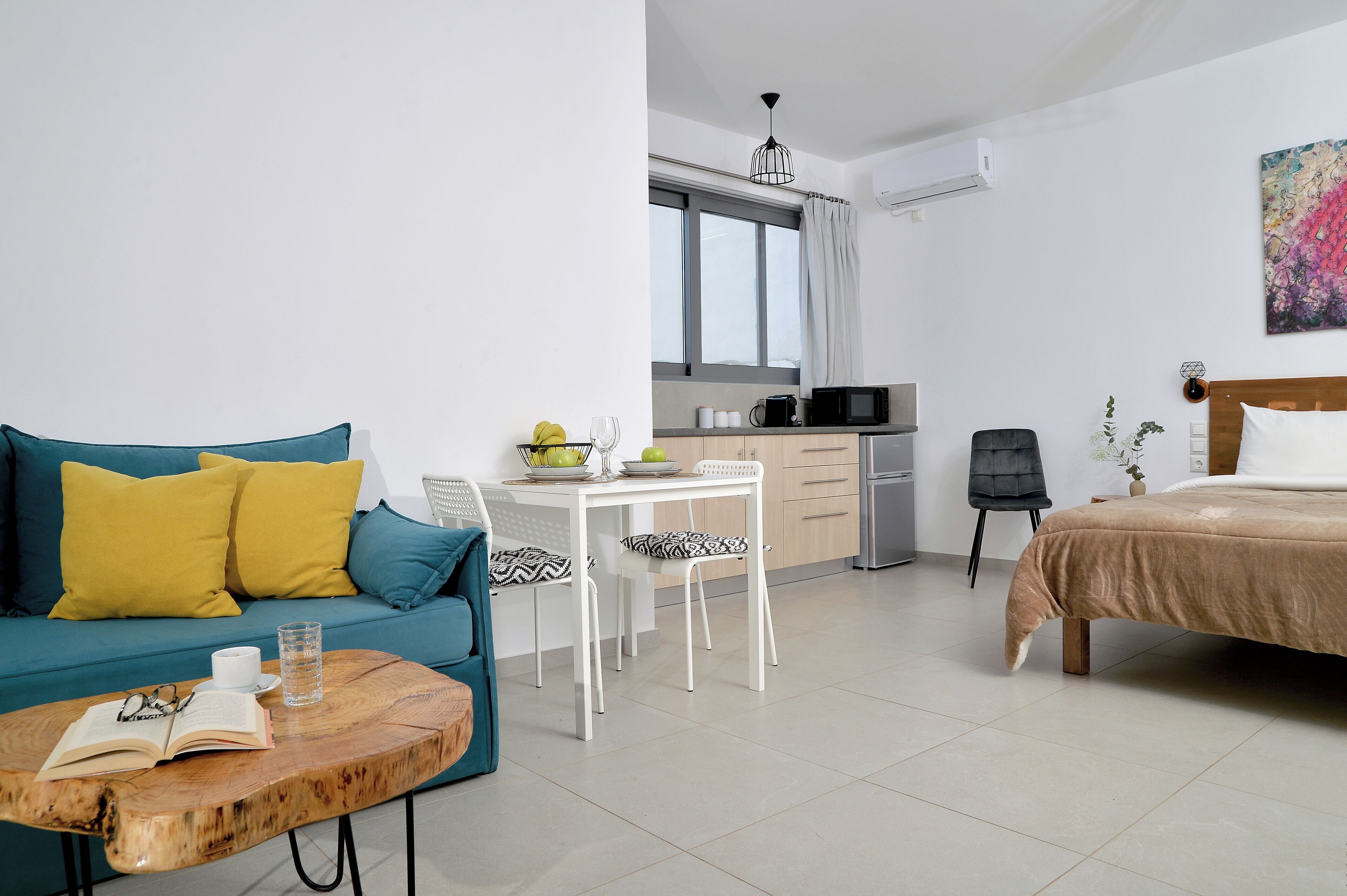 Una sala de estar moderna con sofá, mesa de centro y comedor con mesa y sillas.