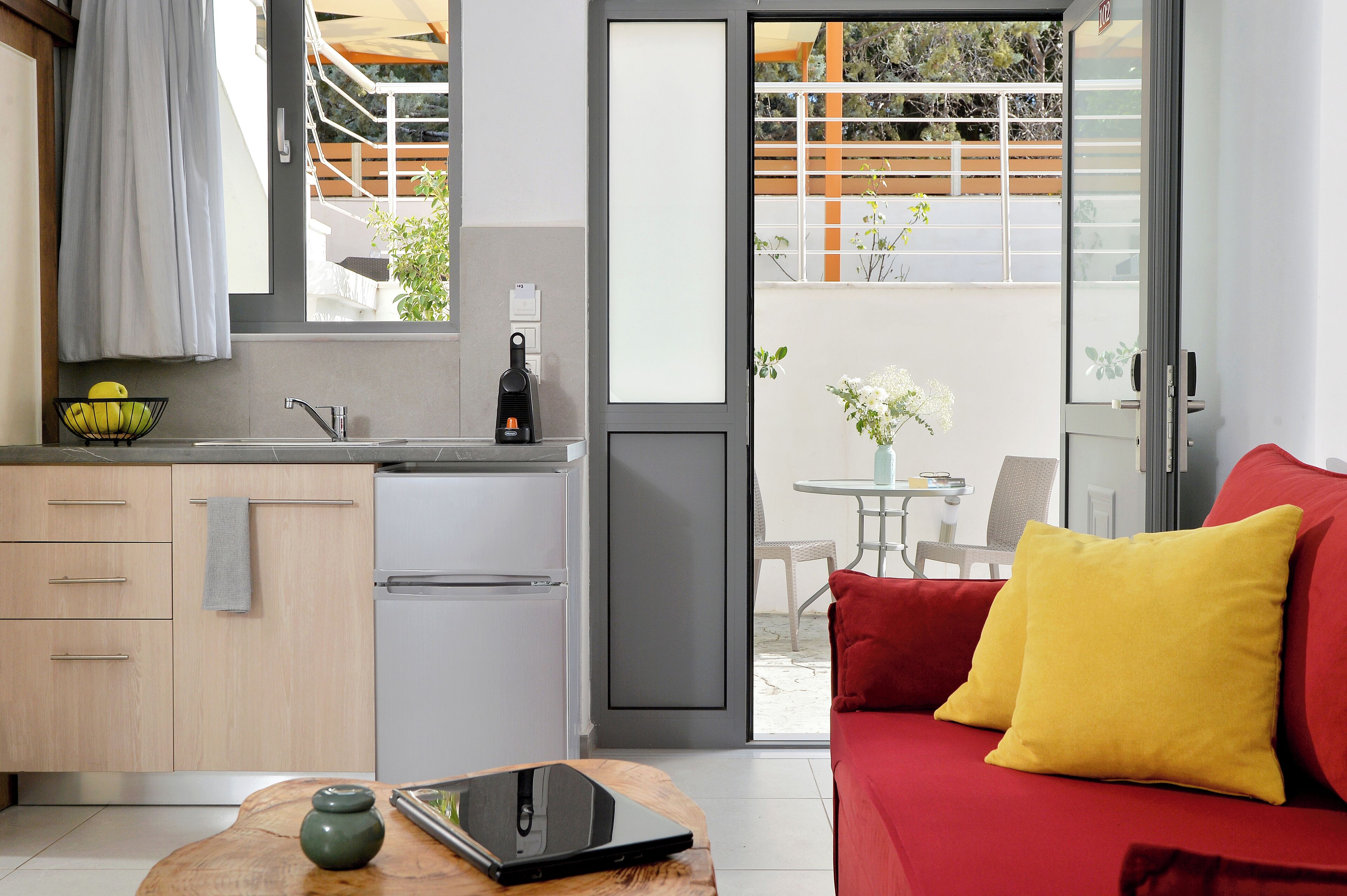 Una cocina moderna con un lavamanos, un refrigerador y una zona de comedor con una mesa y sillas.