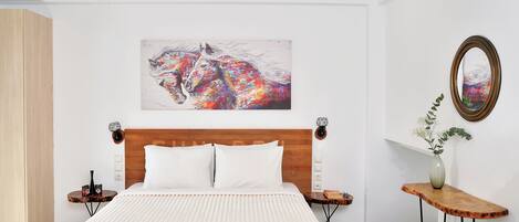 A modern bedroom with a large bed, a wooden headboard, a side table with a vase, and a painting of a horse on the wall.