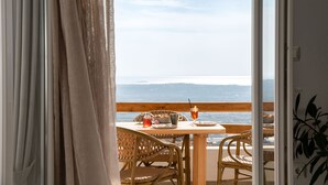 A balcony with wicker chairs, a table with a drink, and a scenic view of the ocean. - Horizon Villa in Naxos Skyline (Naxos)