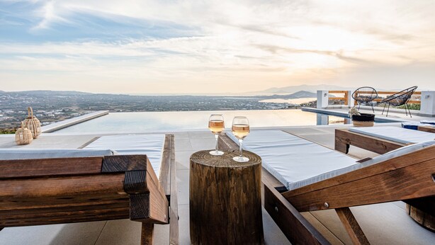 A rooftop terrace with a pool, two glasses of wine, wicker lanterns, and a view of the city and mountains. - Horizon Villa in Naxos Skyline (Naxos)