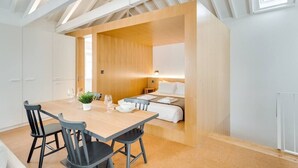 Ett kompakt hotellrum med en matplats, en säng och ett litet pentry.