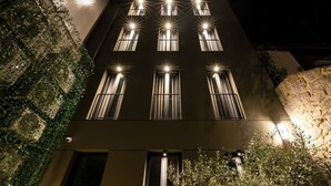 A multi-story building with illuminated windows and a stone facade.