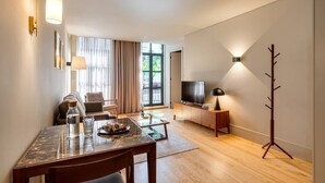 Ein modernes Wohnzimmer mit Essbereich, Fernseher und Garderobe.