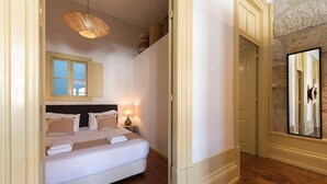 Ein Schlafzimmer mit einem Bett, einer Nachttischlampe und einer Pendelleuchte.