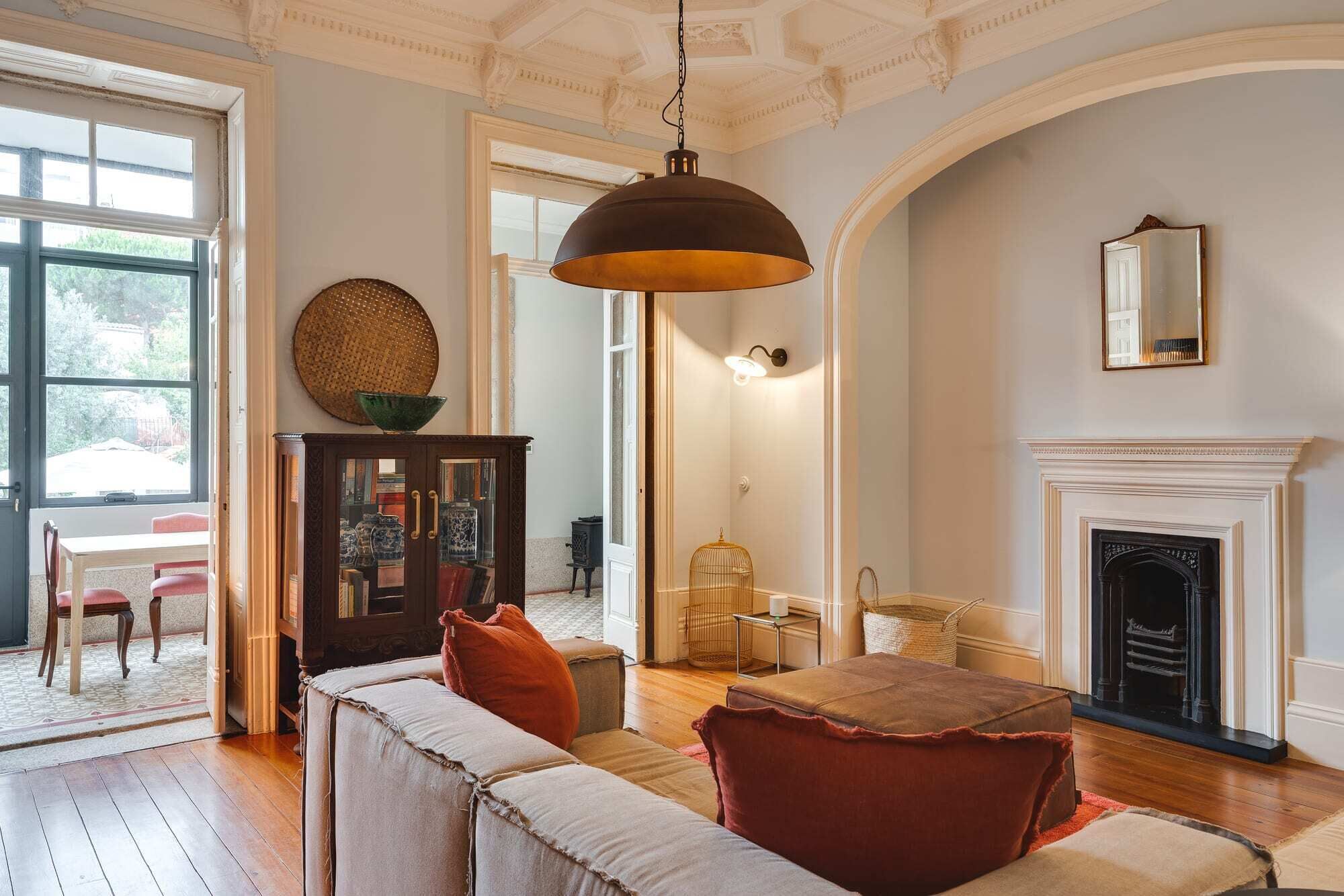 A spacious living room with a fireplace, a large window, and a cozy seating area.