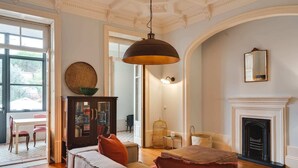 A spacious living room with a fireplace, a large window, and a cozy seating area. - Porto Premium Villa S (Porto)