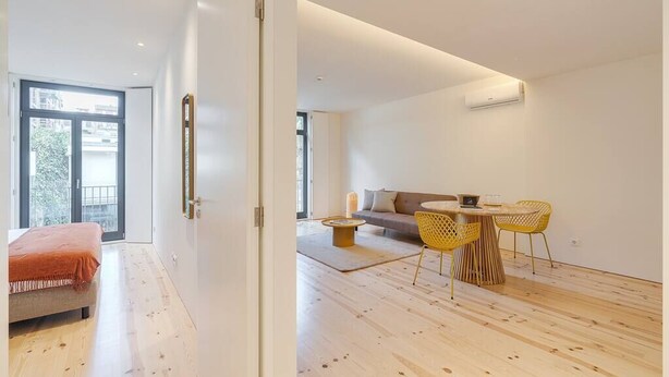 A modern living room with a sofa, a coffee table, and yellow chairs. - Alma da Casa by DA'Home #1D (Porto)