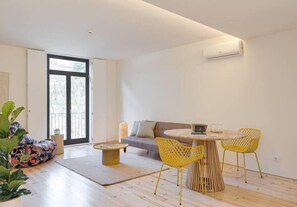A modern living room with a sofa, a round table, and two yellow chairs. - Alma da Casa by DA'Home #1D (Porto)