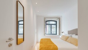 Un dormitorio con cama, ventana y puerta.