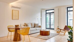 Ein modernes Wohnzimmer mit einem runden Couchtisch, einer Couch und gelben Sesseln.
