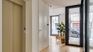 A hallway with a door, a potted plant, and a view of the outside. - Alma da Casa by DA'Home #4E (Porto)