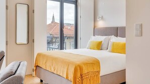 A hotel room with a bed, a chair, a large window, and a view of buildings outside. - Alma da Casa by DA'Home #4E (Porto)