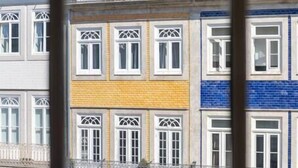 A multi-story building with a yellow and blue facade, featuring a shop on the ground floor named "Zang & Voltaire."