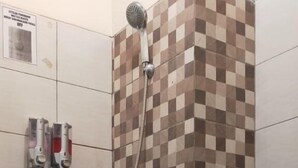 Une salle de bain avec une douche, un lavabo et des toilettes.