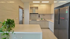 A modern kitchen with white cabinets, a stainless steel refrigerator, and a white countertop. - Starlake Daewoo Managed by Anstay Ha Noi (Hanoi)