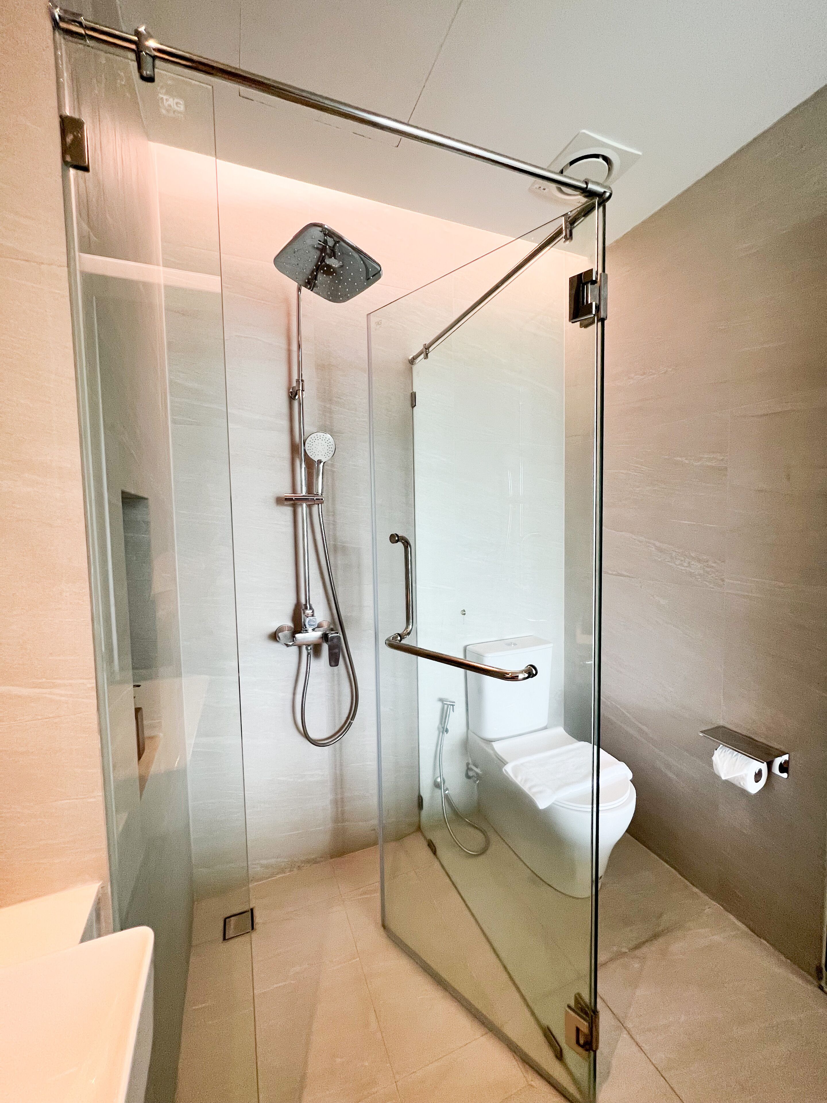 Un baño moderno con ducha acristalada, inodoro y lavamanos.