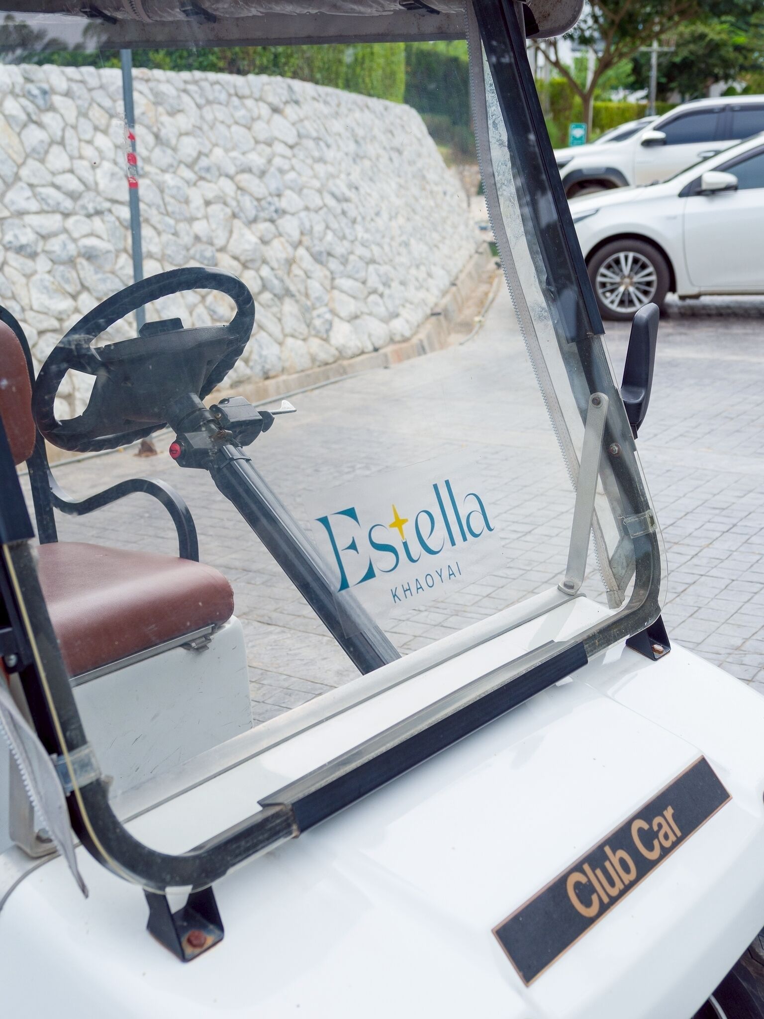 A golf cart with the text "Estella KHAOYAI" and "Club Car" on it.