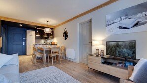 Un salon moderne avec un téléviseur, un canapé et un coin repas.