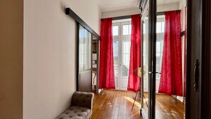 A narrow hallway with a bench, wooden flooring, and red curtains. - T2 Apartment in Mont-Dore, 4 pers, pets allowed, WiFi (Mont-Dore)