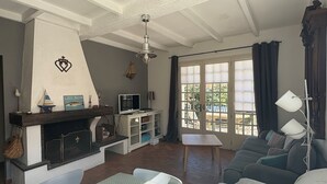 Una sala de estar con chimenea, un sofá, una mesa y un televisor.