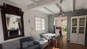 Una sala de estar acogedora con un sofá, una mesa de comedor y un espejo grande.