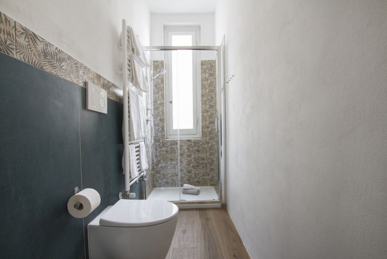 Un bagno con il water, una doccia e un porta asciugamani.