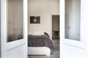 A bedroom with a bed, a painting on the wall, and a door leading to another room. - Casa Gin Tonic, quiet house with terrace (Firenze)