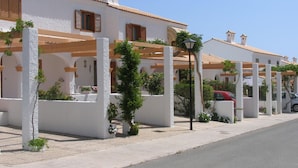 A row of white buildings with terracotta roofs, wooden shutters, and a street lamp. - Cozy apartment in Santa Pola with parking (Santa Pola)