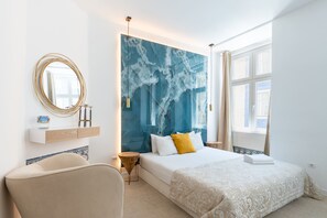 A modern bedroom with a large bed, a round mirror, a bedside table, and a window with curtains. - Lisbon Studios (Lisbon)