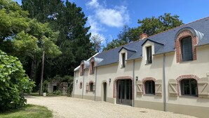 Een gebouw met twee verdiepingen, een grindpad en een stenen muur.