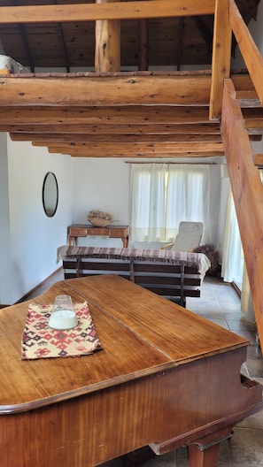A rustic wooden room with a bed, a desk, and a table with a candle. - Esaki Farm Near El Bolson (El Bolson)