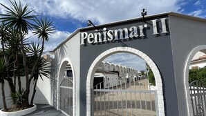 A building entrance with the name 'Penismar II' and a gated driveway.