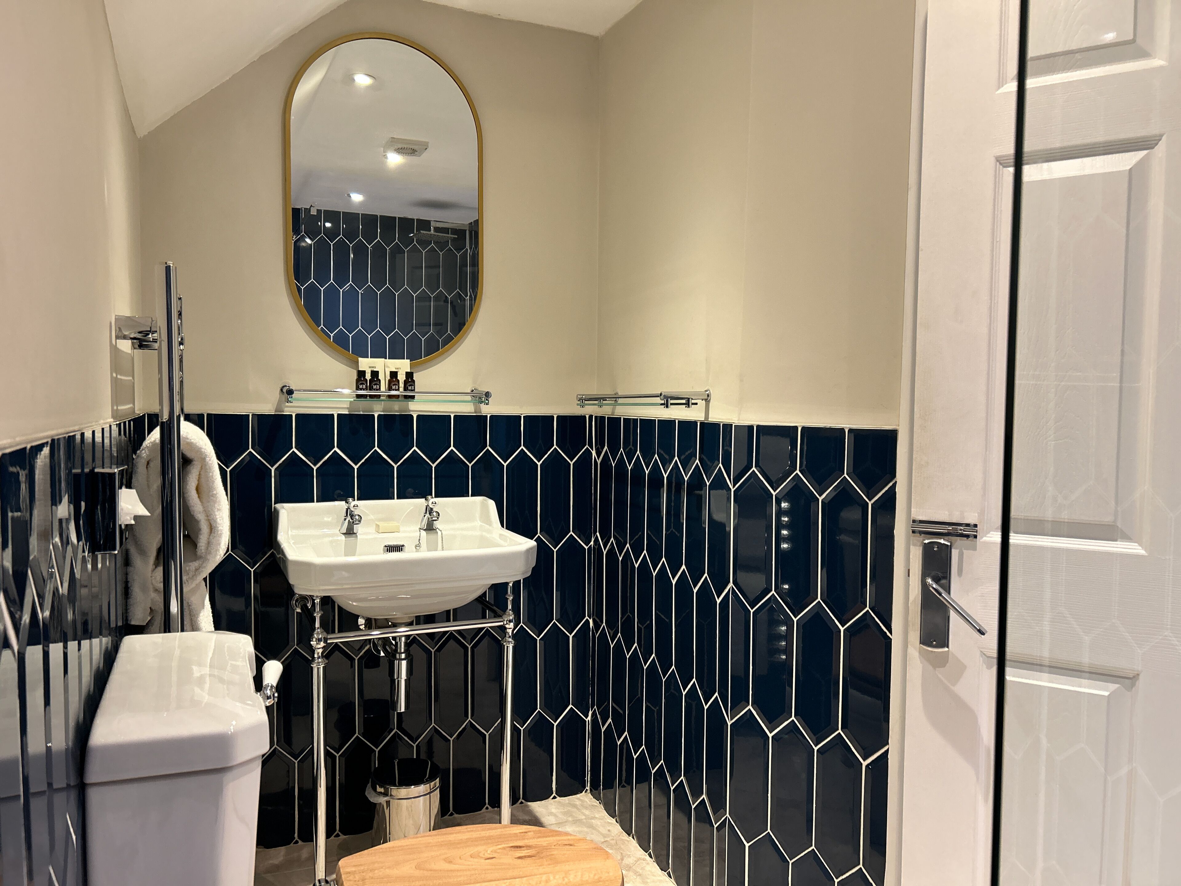 A bathroom with a white sink, a mirror, and a toilet.