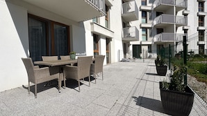 A modern apartment building with outdoor seating and a fenced courtyard. - Aura 40 by Q4 Apartments (Gdansk)