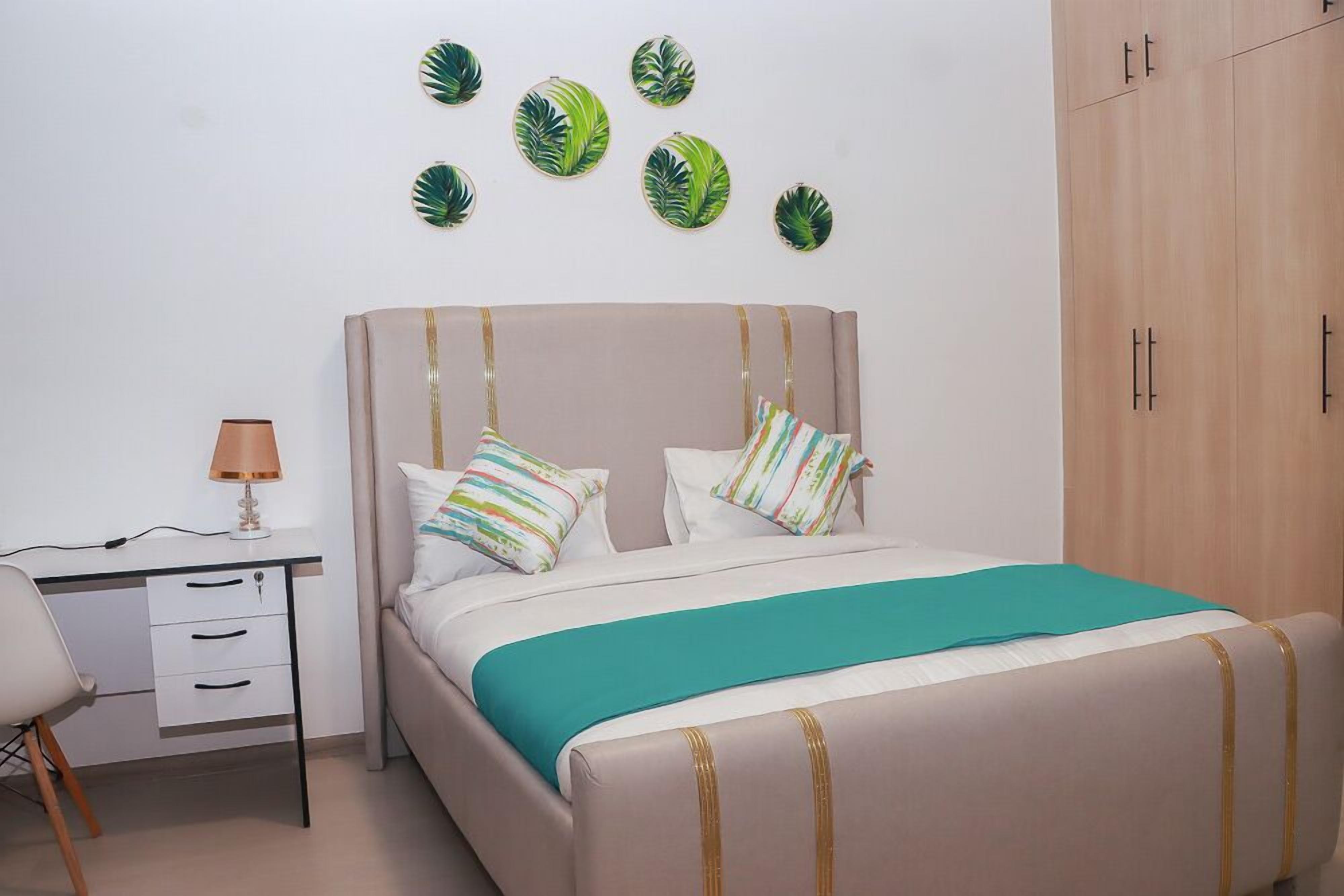 A bedroom with a bed, a desk, and a wardrobe.