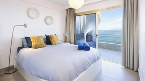 A modern bedroom with a large bed, a floor lamp, and a view of the sea through a sliding glass door. - Our Ocean Penthouse, luxury, views y relax ! (Guía de Isora)