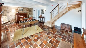 A spacious living area with a foosball table, a stone wall, and a wooden staircase. - Awesome home in Plouguerneau with house sea view (Plouguerneau)