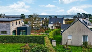 A residential area with modern houses, a well-maintained garden, and a view of the sea. - Awesome home in Plouguerneau with house sea view (Plouguerneau)