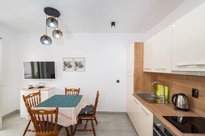 Réfrigérateur, un four, surface de cuisson, vaisselle et ustensiles