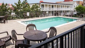 A rooftop pool area with a pool, chairs, and tables. - Two bedroom, 2 bath with pool, newly renovated in 2024! (Ocean City)