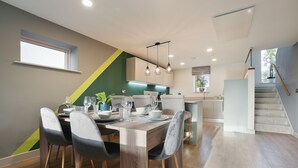 A modern kitchen with a dining area, wooden flooring, and a staircase. - High spec, 4 bed family eco-home w/private gym & tennis courts in Lincolnshire. (Lincoln)