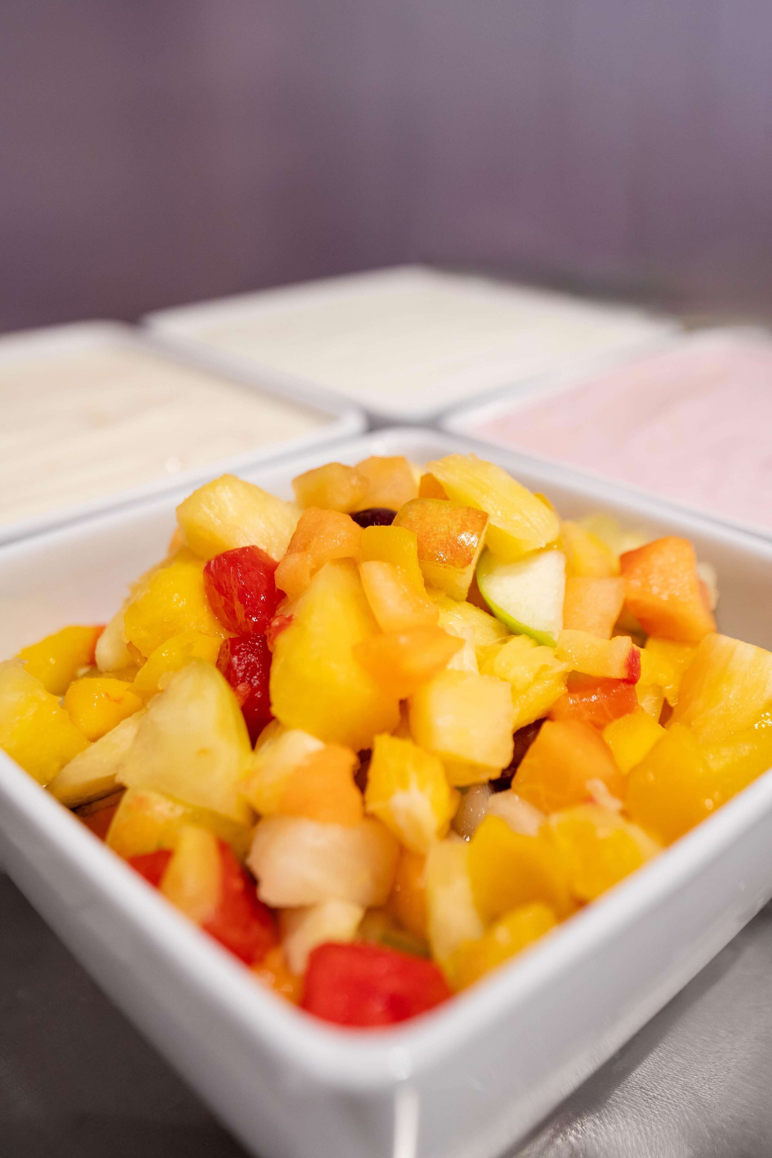 A bowl of diced fruit with a white background.