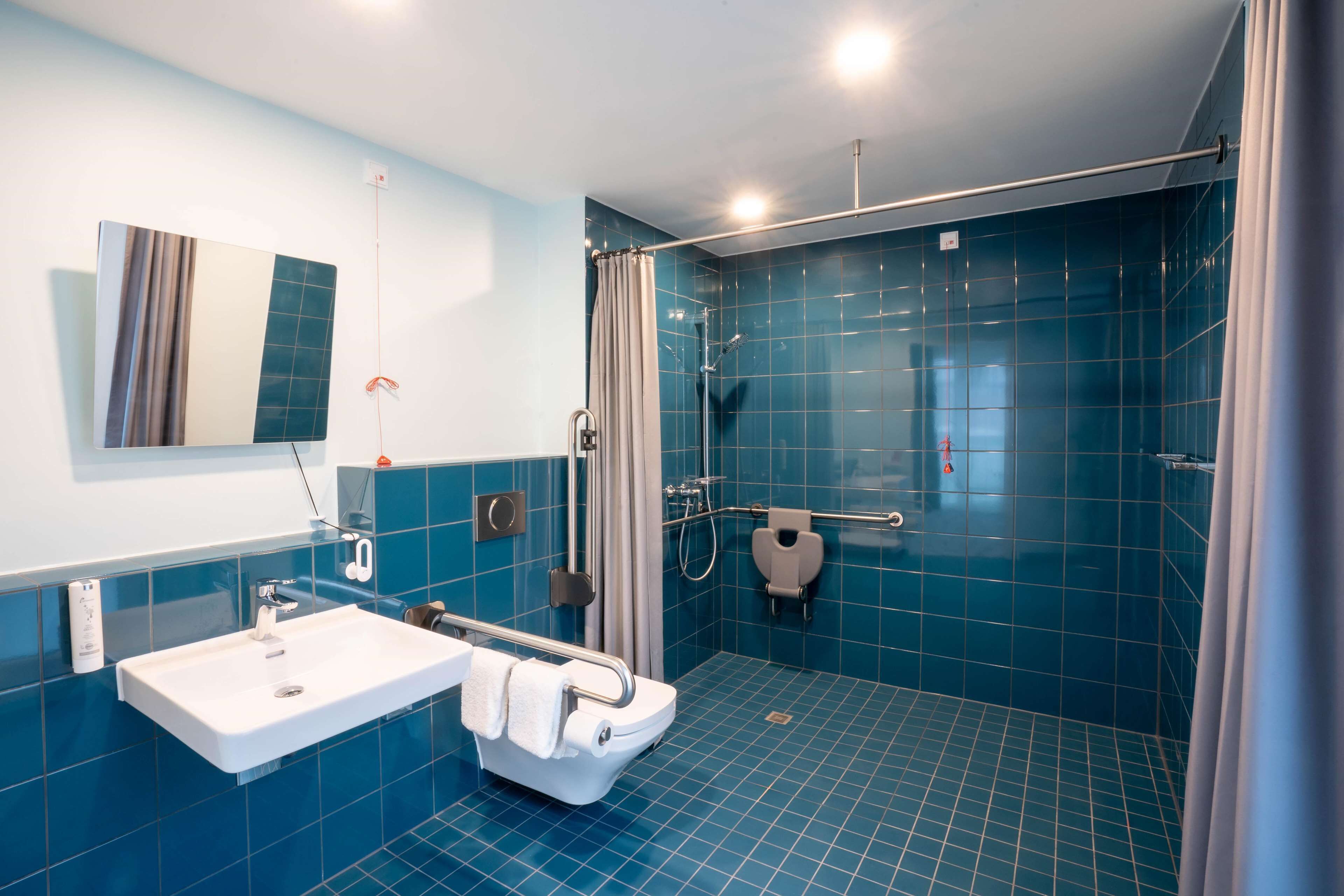 Une salle de bain moderne équipée d’une douche, de toilettes et d’un lavabo.