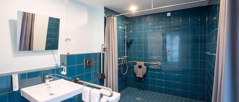 Une salle de bain moderne équipée d’une douche, de toilettes et d’un lavabo.