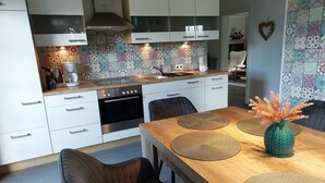 A modern kitchen with white cabinets, a stainless steel oven, and a tiled backsplash.