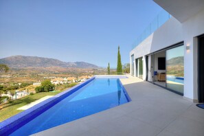 Une piscine moderne offrant une vue dégagée sur le paysage environnant et les montagnes.
