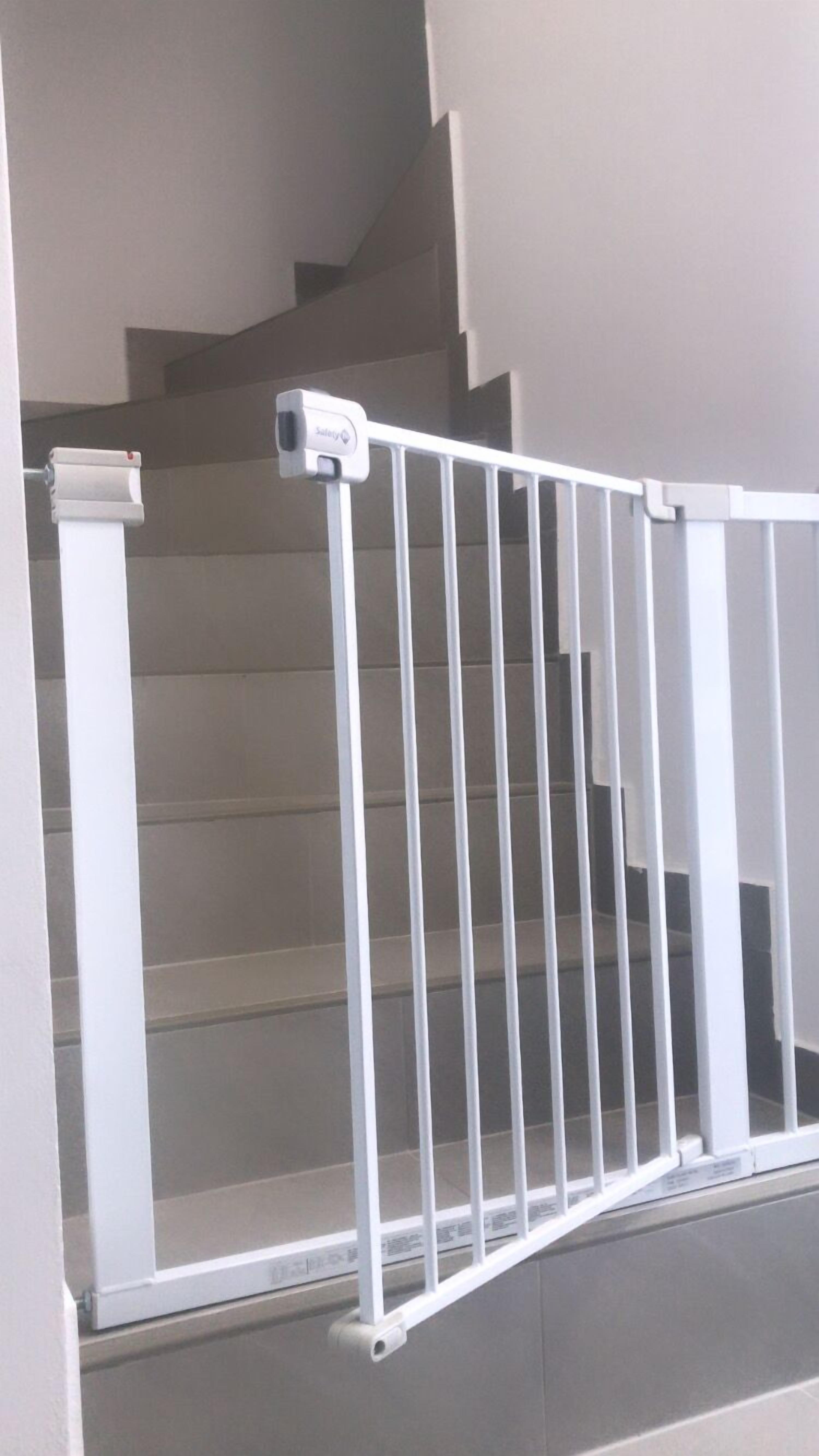 A staircase with a white metal railing and a security camera mounted on the wall.